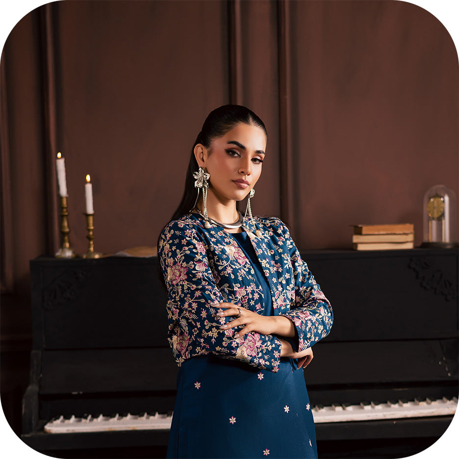 Model wearing a soft winter khaddar outfit from BATIK’s Koyo collection in calm seasonal tones, photographed in natural light.  Close up of textured karandi fabric draping softly, showing detailed stitching and winter craftsmanship.  Full length look of a