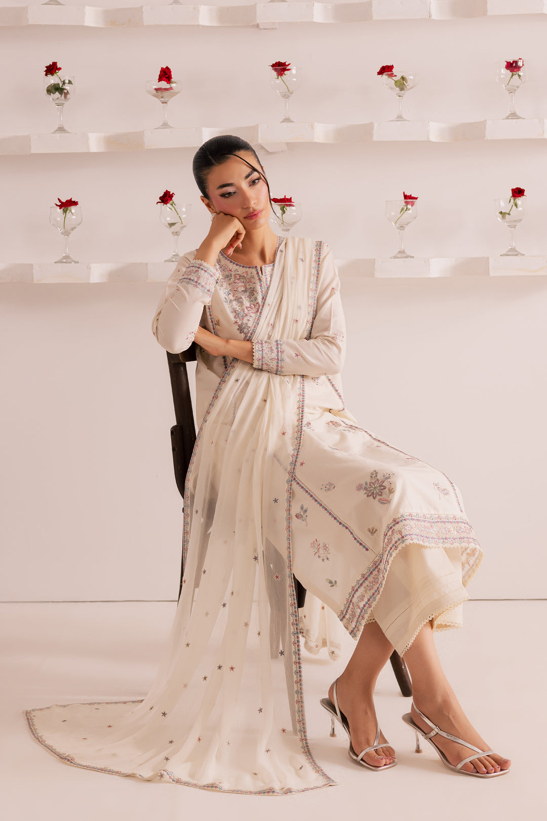 Pakistani model in off-white embroidered pima lawn outfit with lace-trimmed dupatta and pastel floral embellishments. Perfect festive ethnic wear for women -shipped globally from Batik UAE