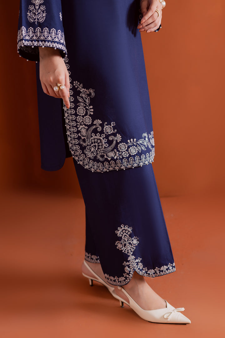 Radiate effortless charm with the Bloom two-piece set, featuring a beautifully composed embroidered midnight blue khaddar shirt that brings elegance due to every detail. The neckline is accented with delicate embroidered tassels, adding a playful yet refined touch.

Paired with matching khaddar culottes, this ensemble offers a graceful and modern silhouette—perfect for daytime festivities or casual gatherings.