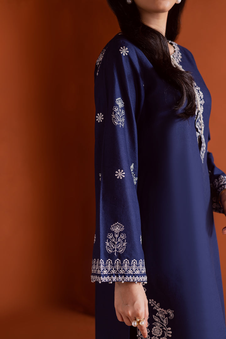 Radiate effortless charm with the Bloom two-piece set, featuring a beautifully composed embroidered midnight blue khaddar shirt that brings elegance due to every detail. The neckline is accented with delicate embroidered tassels, adding a playful yet refined touch.

Paired with matching khaddar culottes, this ensemble offers a graceful and modern silhouette—perfect for daytime festivities or casual gatherings.