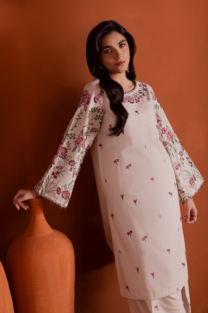Close up of pink and green floral embroidery on beige khaddar shirt neckline. Beautiful craftsmanship and soft fabric texture