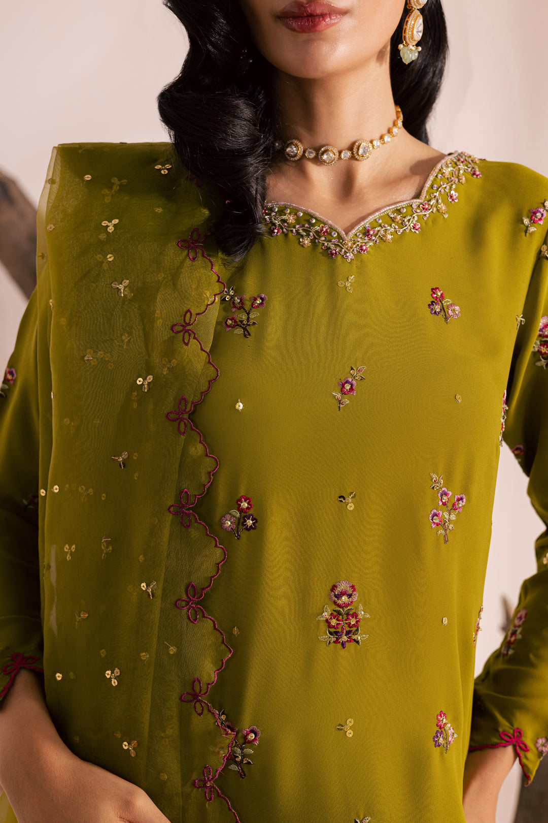 Close-up of olive green embroidered Pakistani outfit for women featuring delicate floral threadwork and sequins. Elegant ready-to-wear ethnic suit from Batik, shipping globally from UAE