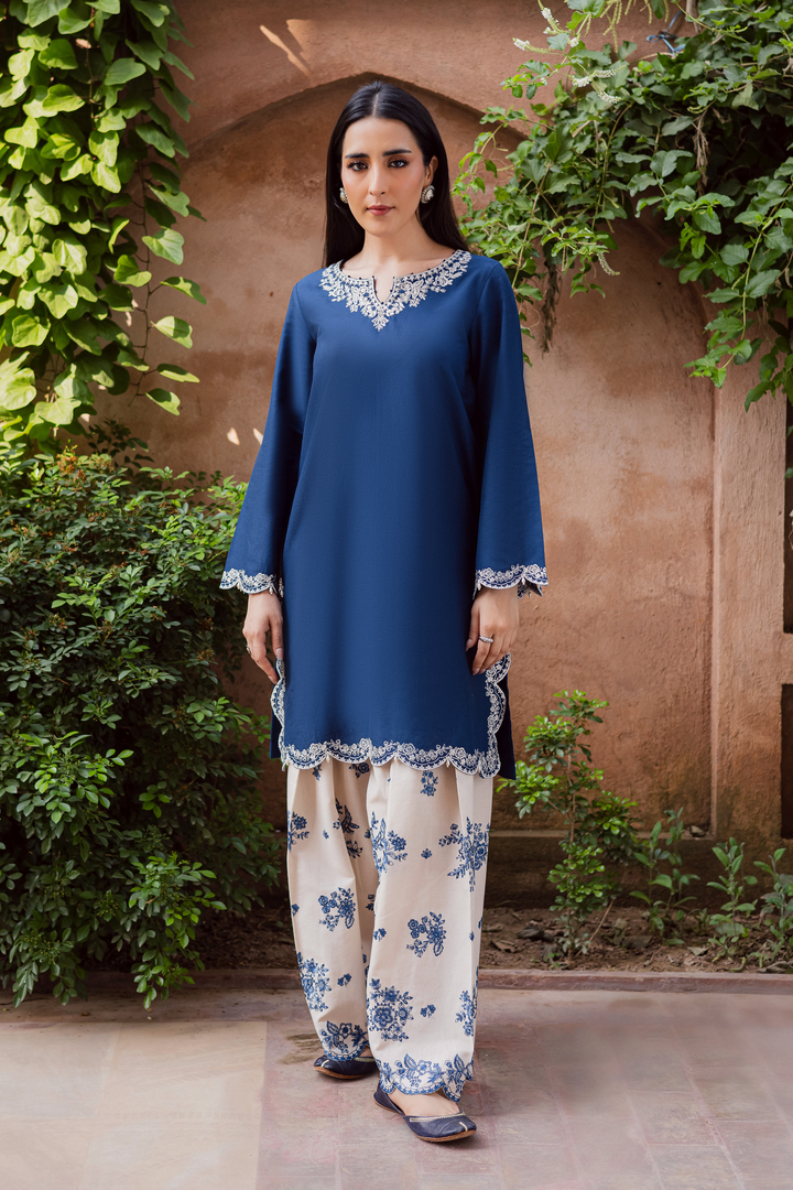 Batik UAE two piece khaddar set featuring a short straight embroidered shirt with scalloped borders keyhole neckline and pearl embellished sleeves paired with a fully embroidered contrasting shalwar. Affordable ethnic South Asian Desi Indian Pakistani designer wear UAE fashion for teens adults girls and women available in sizes XS S M L XL blue white