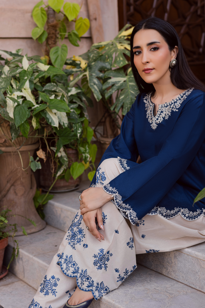 Indian Batik UAE two piece khaddar set featuring a short straight embroidered shirt with scalloped borders keyhole neckline and pearl embellished sleeves paired with a fully embroidered contrasting shalwar. Affordable ethnic South Asian Desi Indian Pakistani designer wear UAE fashion for teens adults girls and women available in sizes XS S M L XL blue white