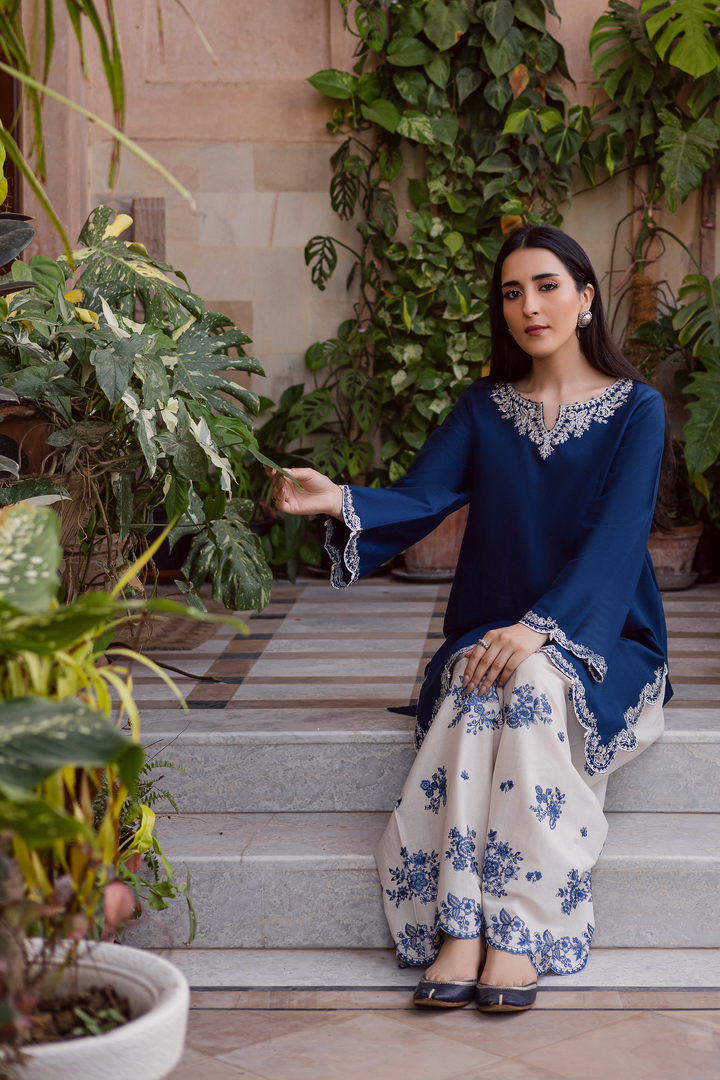 Indian Batik UAE two piece khaddar set featuring a short straight embroidered shirt with scalloped borders keyhole neckline and pearl embellished sleeves paired with a fully embroidered contrasting shalwar. Affordable ethnic South Asian Desi Indian Pakistani designer wear UAE fashion for teens adults girls and women available in sizes XS S M L XL blue white