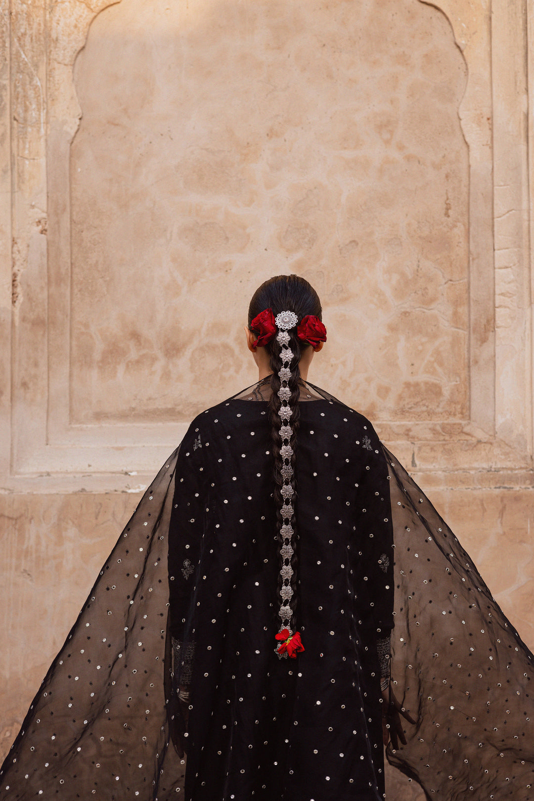 Batik UAE Arbish three piece black raw silk set featuring an embroidered paneled short shirt with crystal detailing paired with an embroidered raw silk sharara and organza dupatta. Affordable ethnic South Asian Desi Indian Pakistani designer wear UAE fashion for teens adults girls and women available in sizes XS S M L XL.