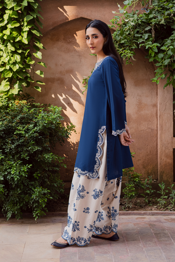 Indian Batik UAE two piece khaddar set featuring a short straight embroidered shirt with scalloped borders keyhole neckline and pearl embellished sleeves paired with a fully embroidered contrasting shalwar. Affordable ethnic South Asian Desi Indian Pakistani designer wear UAE fashion for teens adults girls and women available in sizes XS S M L XL blue white