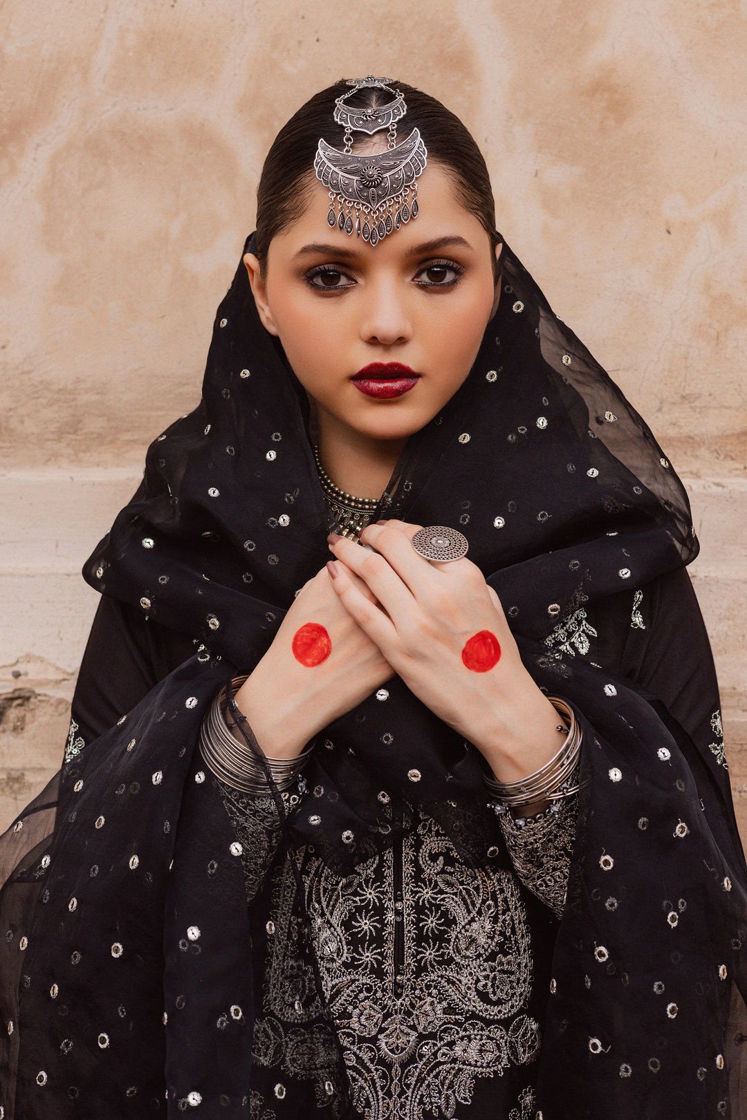 Batik UAE Arbish three piece black raw silk set featuring an embroidered paneled short shirt with crystal detailing paired with an embroidered raw silk sharara and organza dupatta. Affordable ethnic South Asian Desi Indian Pakistani designer wear UAE fashion for teens adults girls and women available in sizes XS S M L XL.