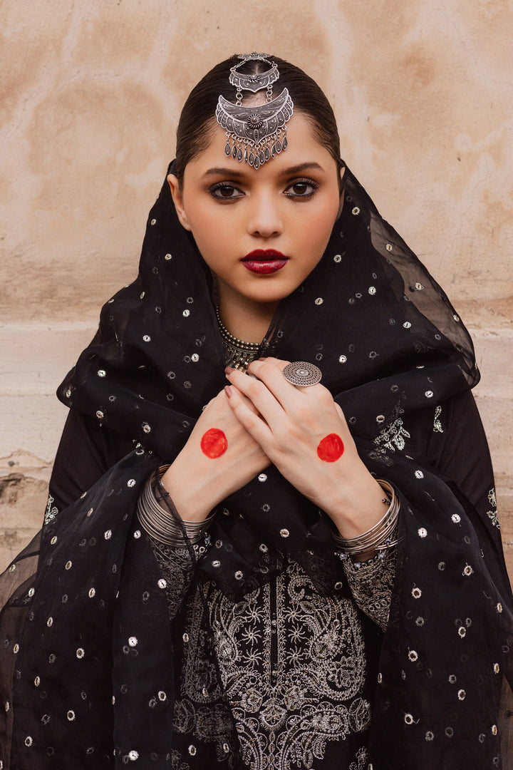 Batik UAE Arbish three piece black raw silk set featuring an embroidered paneled short shirt with crystal detailing paired with an embroidered raw silk sharara and organza dupatta. Affordable ethnic South Asian Desi Indian Pakistani designer wear UAE fashion for teens adults girls and women available in sizes XS S M L XL.