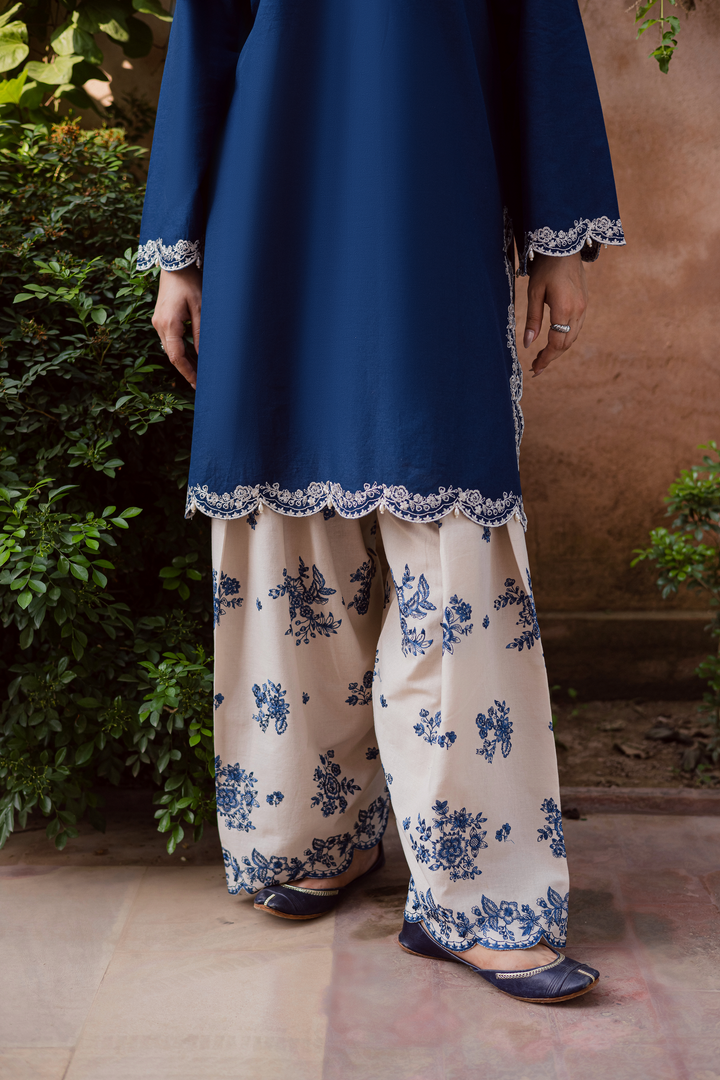 Indian Batik UAE two piece khaddar set featuring a short straight embroidered shirt with scalloped borders keyhole neckline and pearl embellished sleeves paired with a fully embroidered contrasting shalwar. Affordable ethnic South Asian Desi Indian Pakistani designer wear UAE fashion for teens adults girls and women available in sizes XS S M L XL blue white