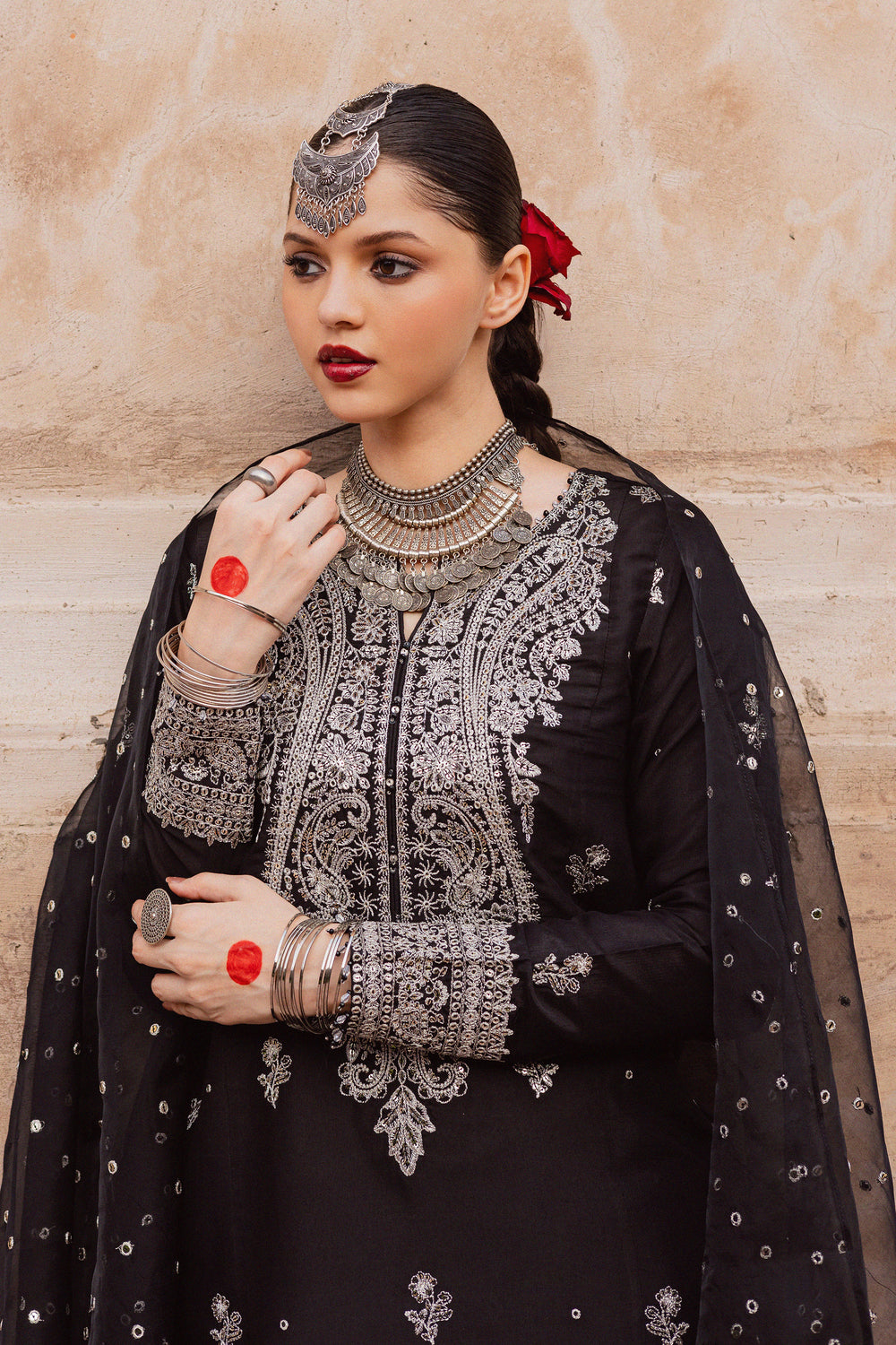 Batik UAE Arbish three piece black raw silk set featuring an embroidered paneled short shirt with crystal detailing paired with an embroidered raw silk sharara and organza dupatta. Affordable ethnic South Asian Desi Indian Pakistani designer wear UAE fashion for teens adults girls and women available in sizes XS S M L XL.