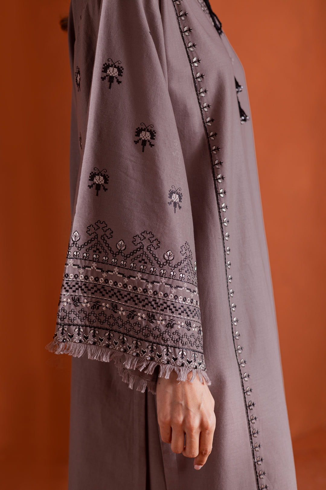 Batik UAE Crossword two piece khaddar set featuring a drop shoulder paneled shirt with cross stitch embroidery tassel neckline and fringed sleeves. Affordable ethnic South Asian Desi Indian Pakistani designer wear UAE fashion for teens adults girls and women.