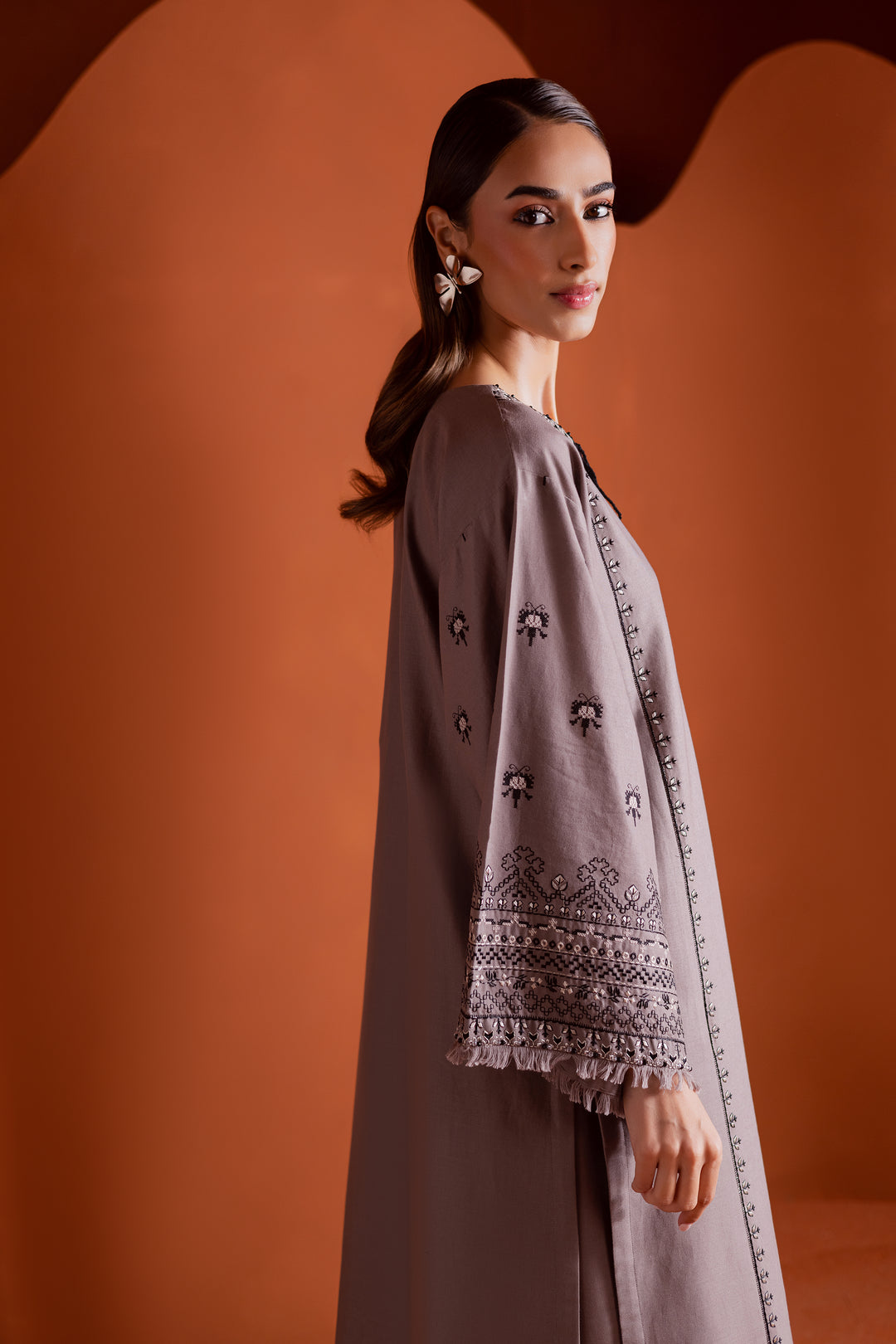 Batik UAE Crossword two piece khaddar set featuring a drop shoulder paneled shirt with cross stitch embroidery tassel neckline and fringed sleeves. Affordable ethnic South Asian Desi Indian Pakistani designer wear UAE fashion for teens adults girls and women.