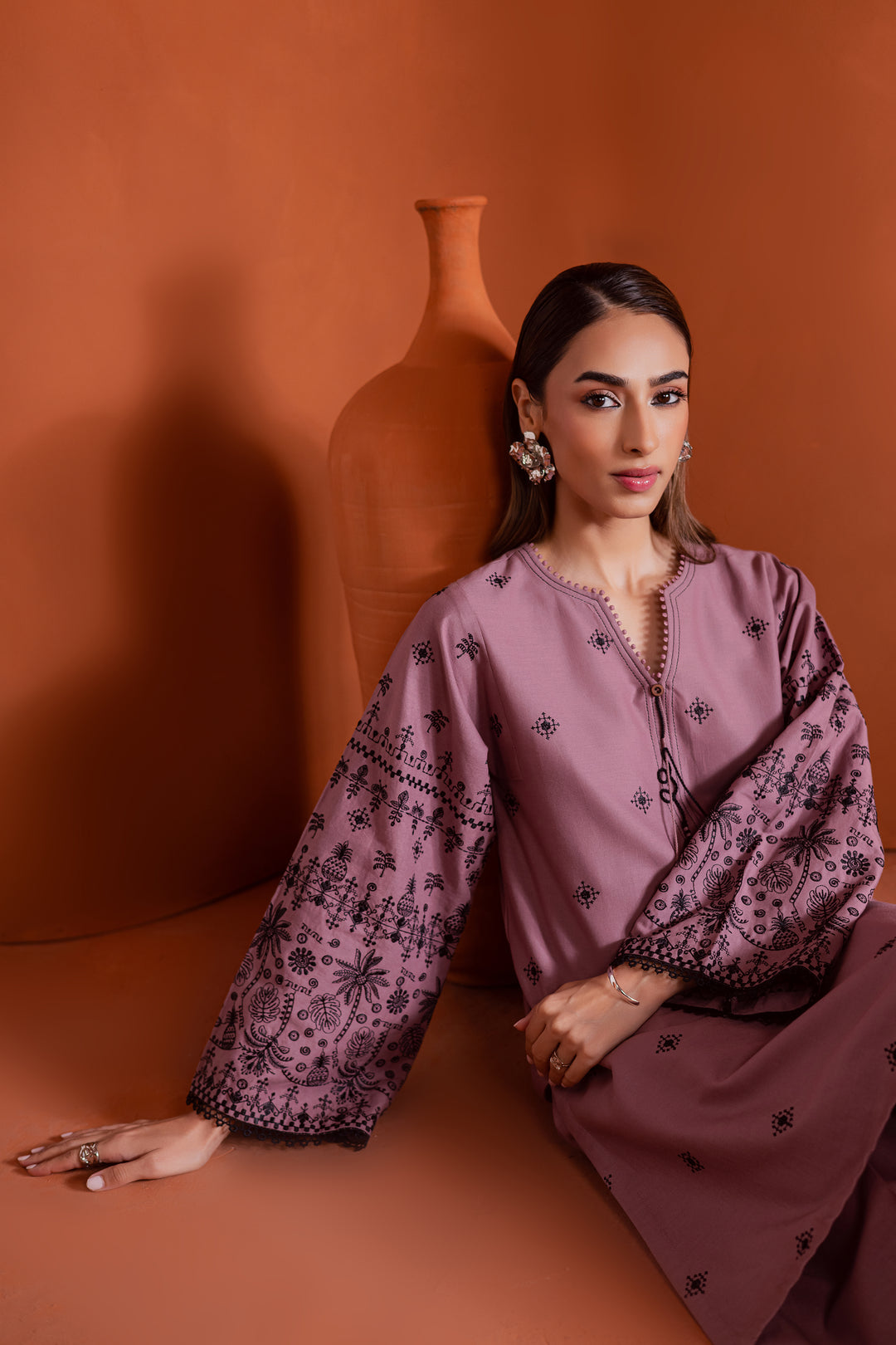 Pakistani woman styled in pink khaddar 2-piece embroidered outfit featuring straight pants and wide sleeves. Elegant and minimal South Asian ready-to-wear by Batik - ideal for casual chic or semi-formal occasions. Fast delivery in UAE and international shipping.