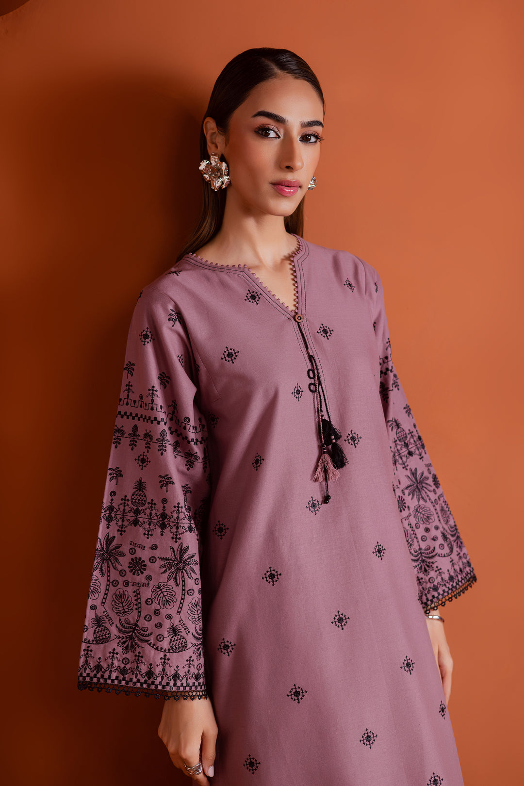 stylish South Asian outfit for women — onion pink embroidered khaddar shirt and culottes with tassel detailing. A versatile stitched Pakistani suit for everyday wear, office looks, or festive occasions. Available online with easy delivery across GCC.