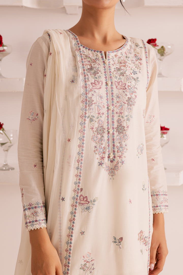 Elegant close-up of Pakistani woman in off-white embroidered lawn outfit, holding a lightweight lace-edged dupatta. Timeless ethnic wear by Batik with global shipping and UAE delivery